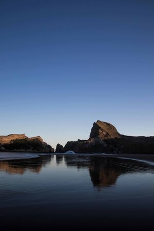Reflections of Castle Rock in the lagoon.